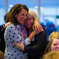 Two women hug at fundraising event