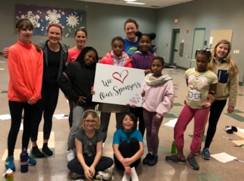 Girls on the Run participants hold a sign that says we love our sponsors