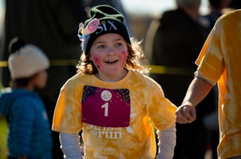 Girls on the Run participant smiles while running the 5K